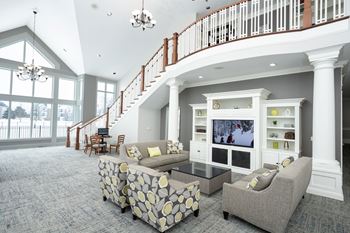 A living room with a staircase and a flat screen tv